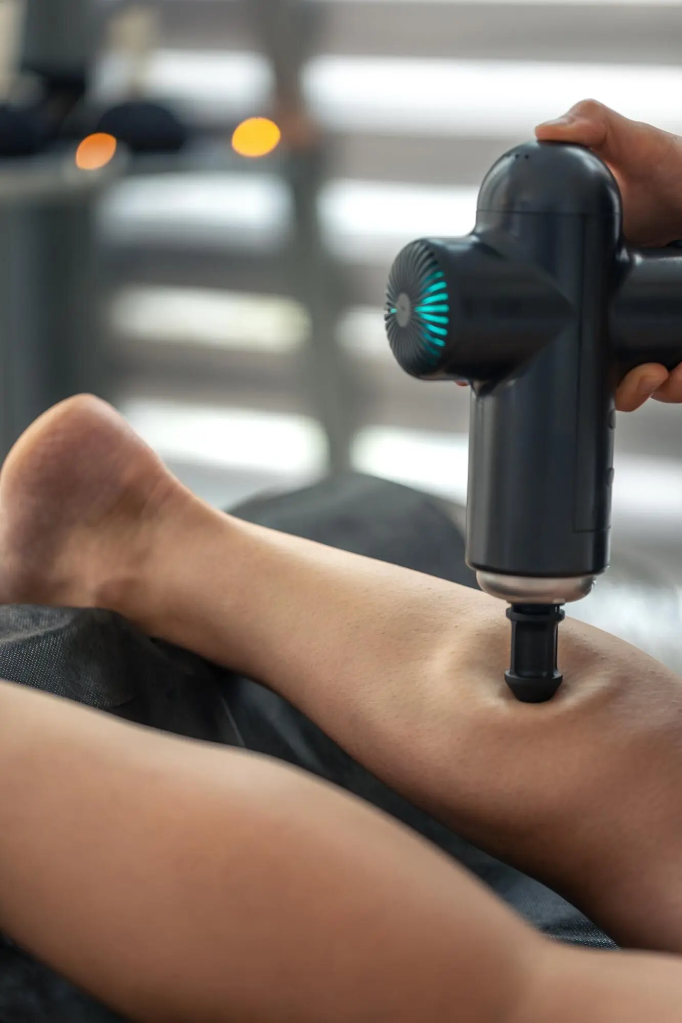 Perkussive Triggertherapie an der Wade im Studio mit Massage-Kegelaufsatz.